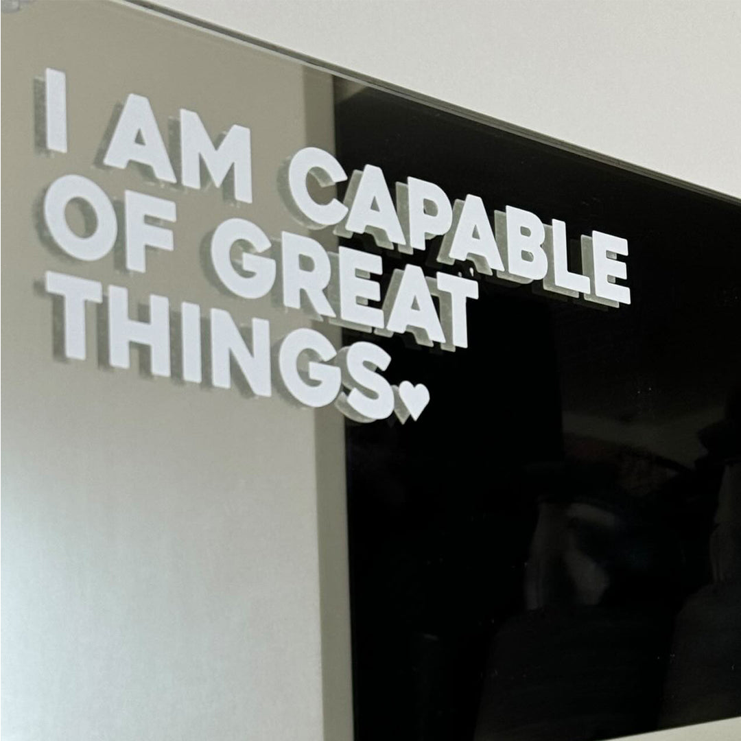 affirmation sticker 'i am capable of great things' in white text installed onto a mirror
